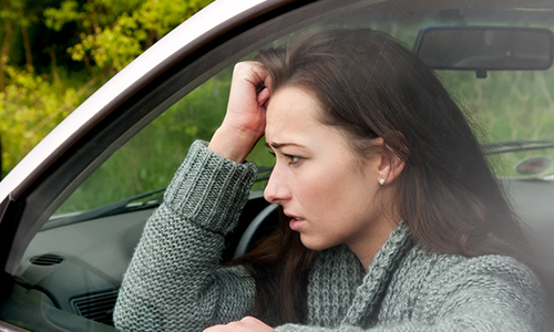 Eine Frau im Auto mit Schäden